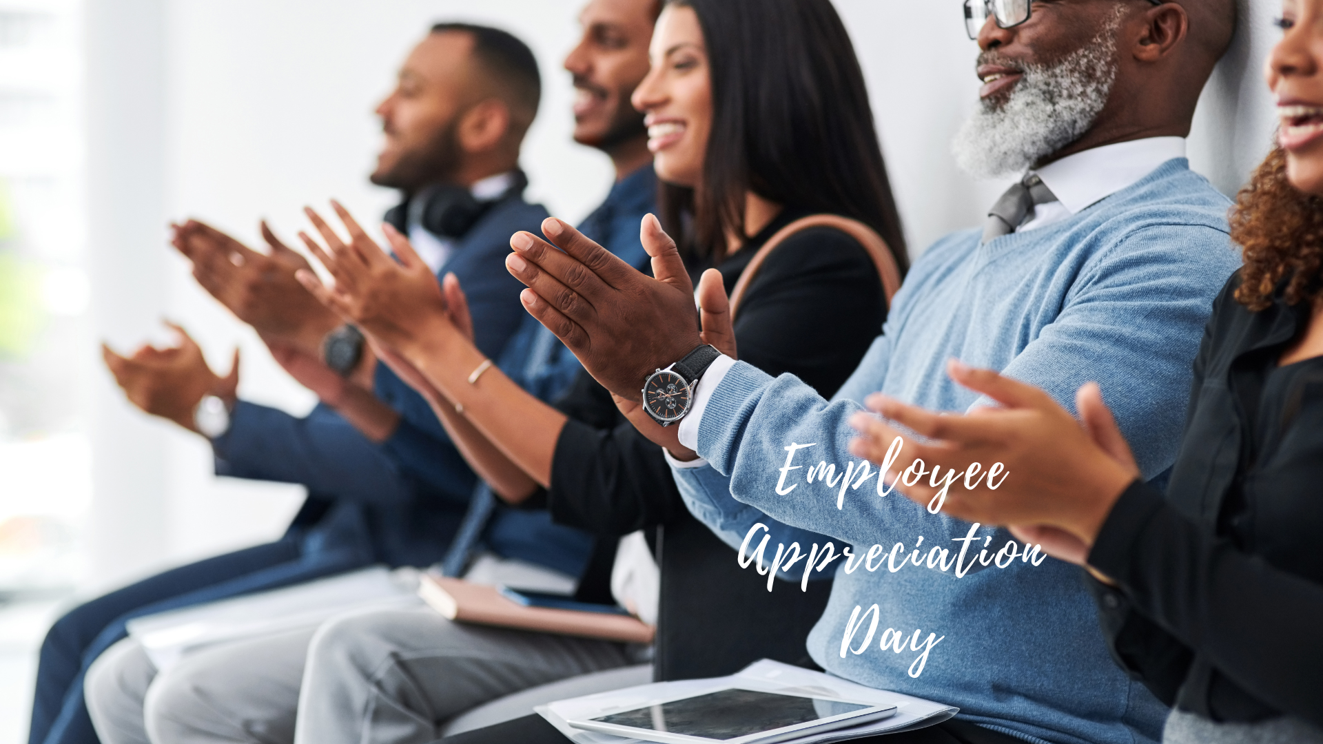 A group of people clapping with the text employee appreciation day.