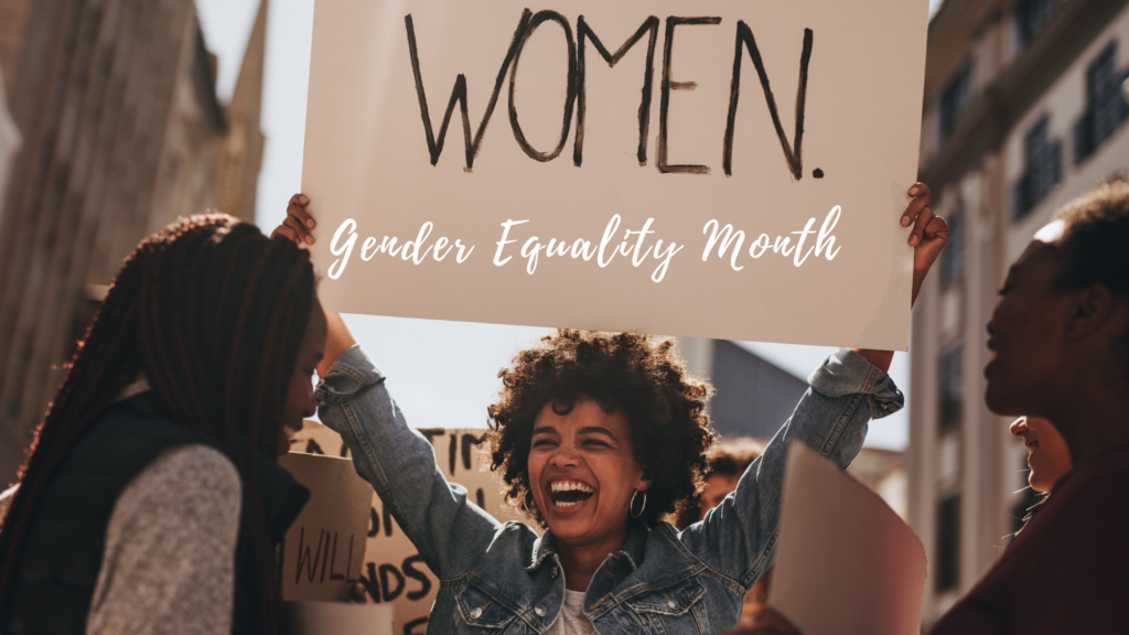 A group of women holding up a sign that says women gender equality month.