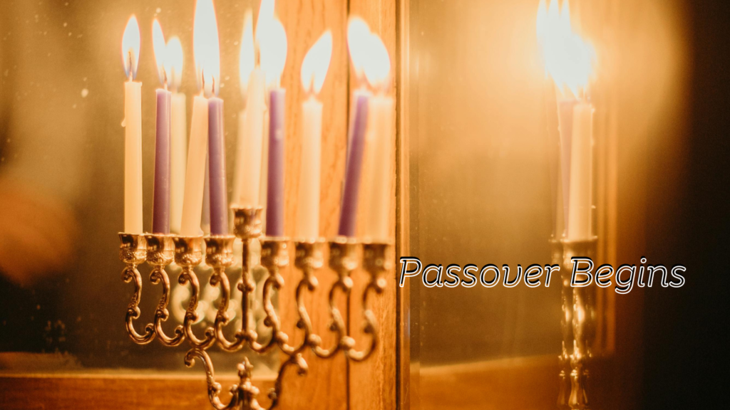 Candles lit on a menorah with the text "passover begins" indicating the start of the jewish holiday.