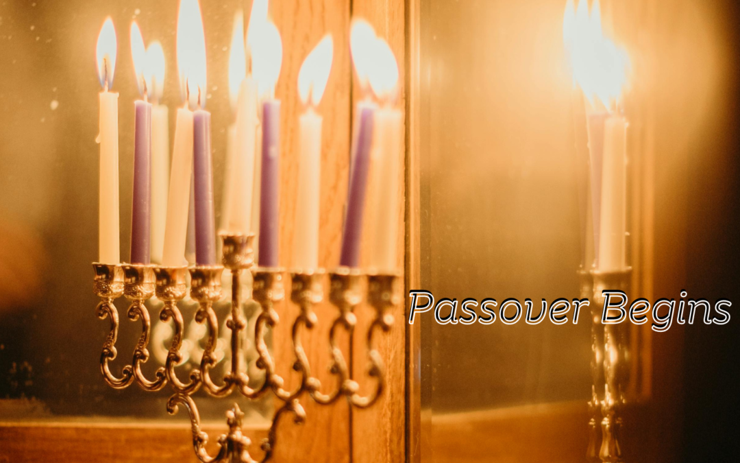 Candles lit on a menorah with the text "passover begins" indicating the start of the jewish holiday.