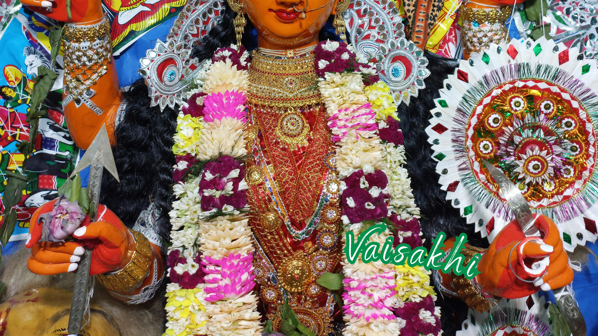 Colorfully adorned deity figure at vaisakhi festival with vibrant flowers and embellishments.