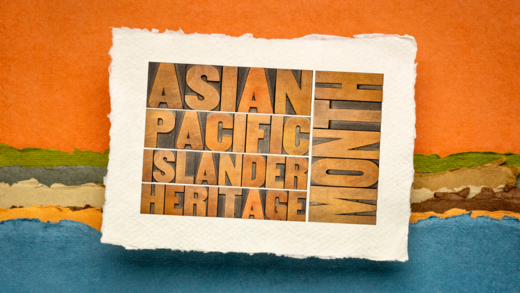 Text "asian pacific islander heritage month" on torn paper over a colorful, striped background.